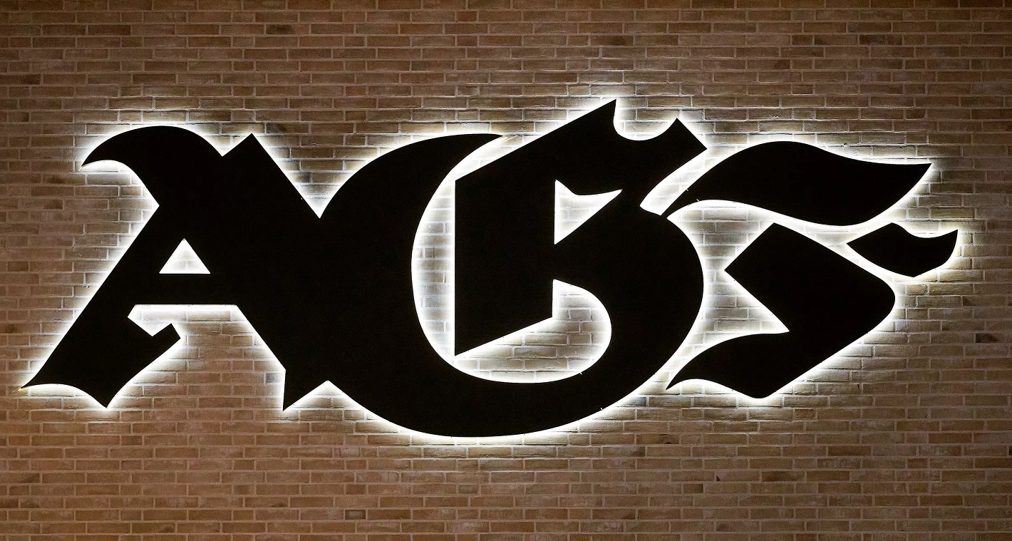AGF's logo i gotiske bogstaver på væggen til klubhuset på Fredensvang