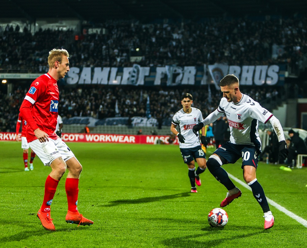 Mikkel Duelund dribler med bolden overfor Silkeborg-spiller, mens Eric Kahl ser til i baggrunden.