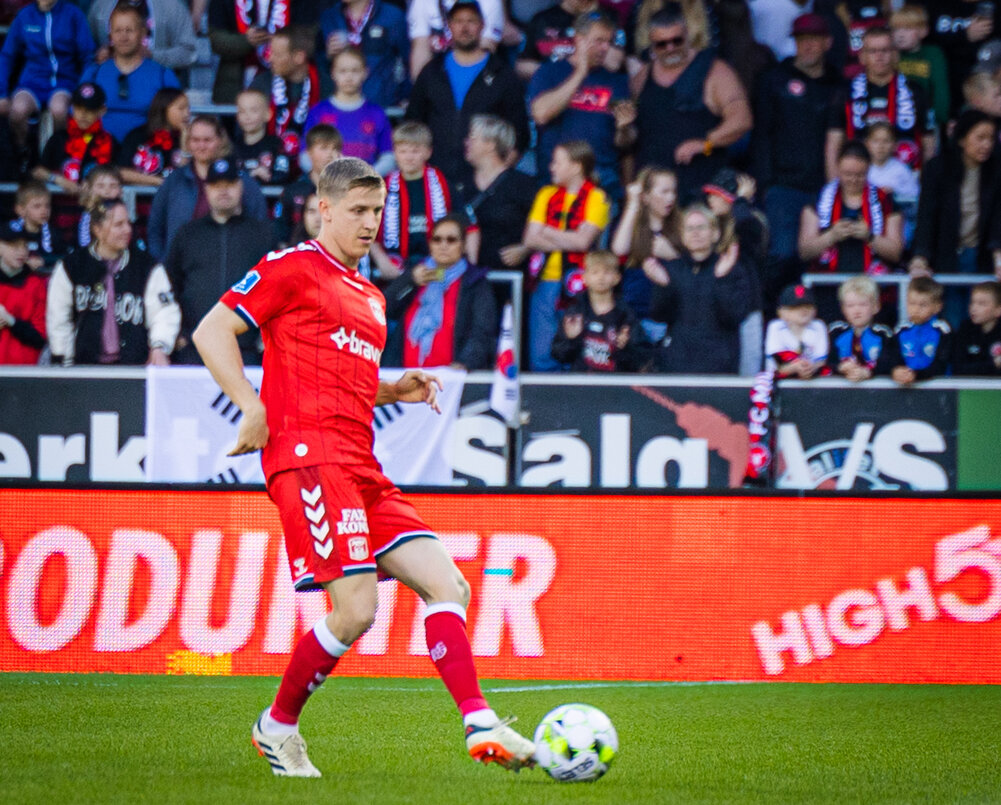 Mats Knoester med bolden i rød AGF-trøje.