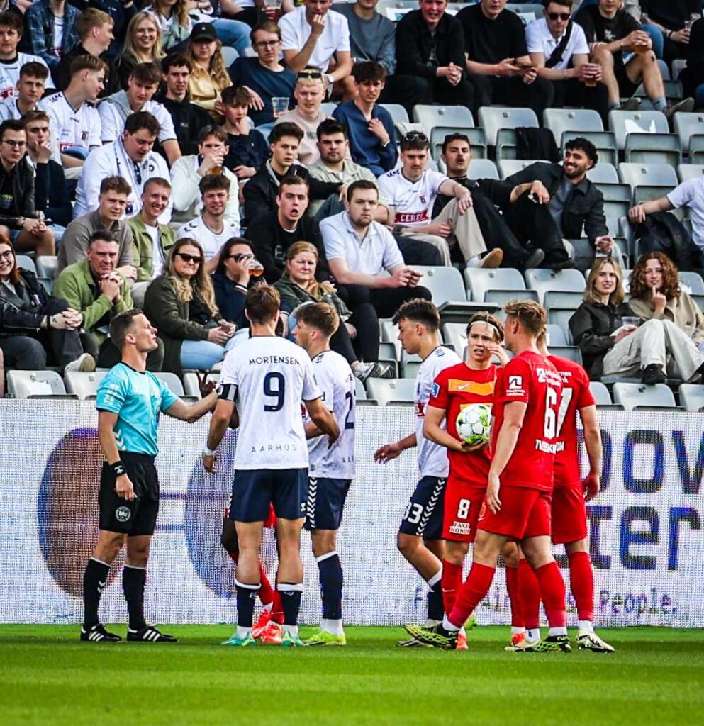 Dommer Jonas Hansen diskuterer med AGF-spillerne.