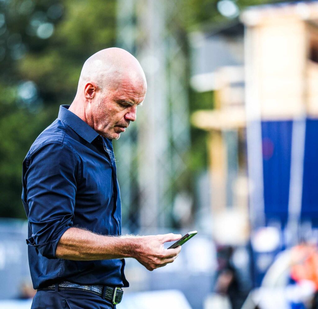 Stig Inge Bjørnebye tjekker sin telefon.