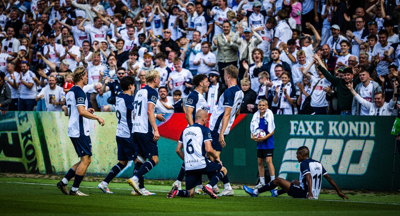 Syv AGF spillere jubler sammen med glade tilskuere og bolddreng.