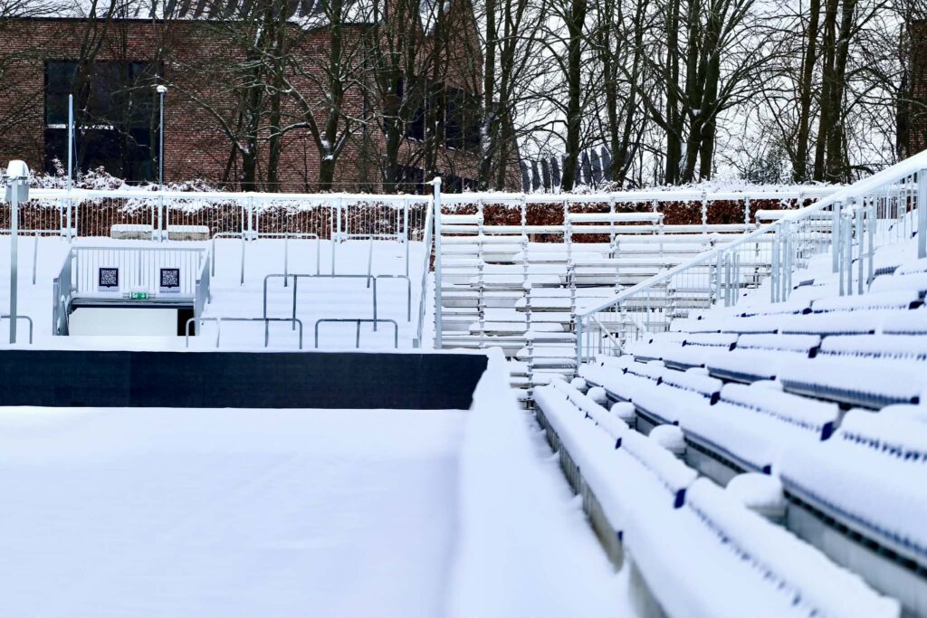 Ceres Park Vejlby tilskuerrækker dækket af sne i februar 2026.